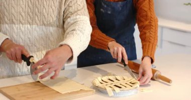 Kavrulmuş turta hamurunu hazırladıktan ve mutfak tezgahına örgü ördükten sonra birkaç dilim şerit. Aşçılık, ortaklık, zanaat, kırsal, yerli, işçilik, takım çalışması