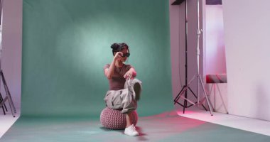 Stüdyoda, güneş gözlüğü takmış, rahat görünen Asyalı bir kadın. Moda, tarz, gözlük, poz, boş zaman, lüks