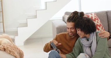 İçeriği ve salonun zemininde gülmeyi gösteren akıllı telefonları dinleyen bir çift. Romantizm, samimiyet, bağlantı, eğlence, modern, samimi, yaşam tarzı