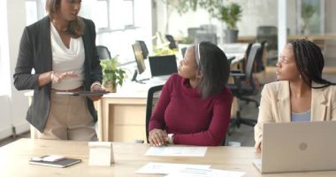 Çeşitli iş arkadaşları tableti tıkırdatıyor, çizelgeleri açıklıyor ve ofis toplantısında dizüstü bilgisayara kafa sallıyor. İşbirliği, takım çalışması, iş, profesyonel, sunum, modern, iletişim