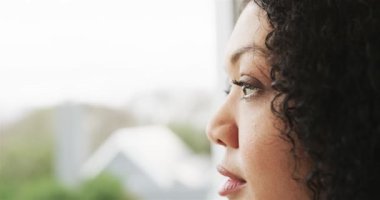 Kadının nefes alıp vermesi, gözlerini açması ve ev penceresinden çatıya bakması, boşluğu kopyalaması. Düşüncelere dalma, sükunet, farkındalık, doğal ışık, iç gözlem, huzur