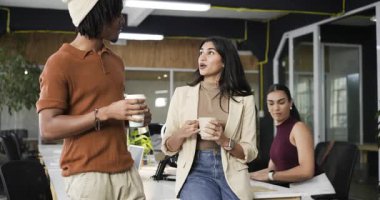 Afrika kökenli Amerikalı erkekler fincanla konuşurken, biri de masada kupa tutarken çeşitli iş arkadaşları sohbet ediyor. İşbirliği, iletişim, girişim, profesyonellik, gündelik, takım çalışması, modern