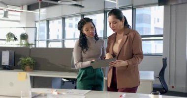 Çeşitli iş arkadaşları masadaki tablet çizelgelerini inceliyor, galibiyeti fark ediyor, şaşırıp sarılıyorlar. İşbirliği, takım çalışması, profesyonel, modern, kurumsal, başarı, başarı