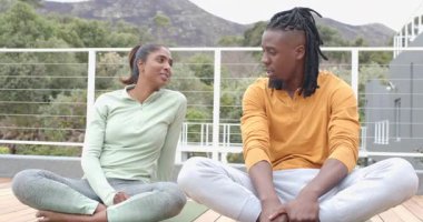 Güvertedeki yoga minderlerinde oturan çeşitli arkadaşlar tepe tepe üzerinden gülümseyerek beşlik çakıyorlar. Açık hava, dostluk, farkındalık, dostluk, işbirliği, refah, manzara