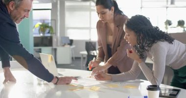 Üst düzey kişiler planlama için yapışkan notlar göstererek masada akış şemasını organize eden çeşitli iş arkadaşları. İşbirliği, takım çalışması, beyin fırtınası, ofis, planlama, yenilik, iletişim