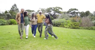 Çeşitli aileler çim kaynaşmasına girerken, kızlar atlıyor ve son sınıflar kızlarını kaldırıyor. Aile, çok nesilli, açık hava, doğa, birliktelik, mutluluk, bağ