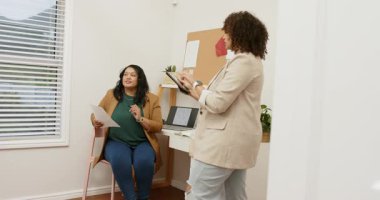 Kağıt dinleme tabletine işaret eden farklı iş arkadaşlarına bakıp ofiste telefonları kaydırmak. İşbirliği, takım çalışması, iletişim, profesyonellik, dijital, çalışma alanı, yenilik