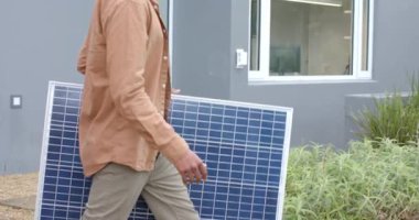 İzleme yolu boyunca kurulumu planlarken güneş panelinin yerleştirildiğini gösteren mesajdan sonra erkek yükleyici. Sürdürülebilirlik, yenilenebilir enerji, modern ev, çevre dostu, açık hava, inşaat, teknoloji