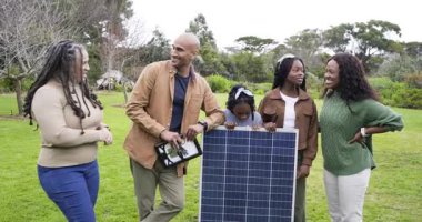 Çimenlikte beş farklı güneş paneli ailesi, baba konumlandırması, anne inceleme modülü. Aile, sürdürülebilirlik, çevre dostu, açık hava, uyum, modern, teknoloji