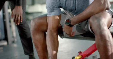 Afrikalı Amerikalı antrenör, spor salonunda halter kıvrımlarını taklit eden müşteriye rehberlik ediyor. Güç, zindelik, eğitim, egzersiz, motivasyon, sağlık, atletizm