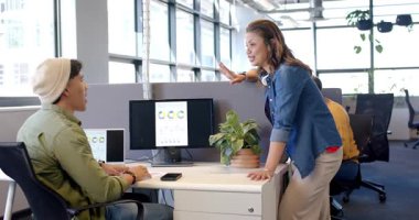 Çalışma masasındaki çeşitli iş arkadaşları, içeri giren kadın, adam yazarken el kol hareketi yapan adam. İşbirliği, takım çalışması, iletişim, üretkenlik, modernlik, profesyonellik, veri analizi