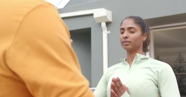 Çeşitli meditasyon partnerleri terasa çıkıp sakin bir şekilde avuçlarını birbirine bastırıyorlar. Dinginlik, farkındalık, bağlantı, uyum, sağlık, sükunet, modern