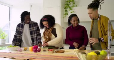 Çeşitli arkadaşları hazırlamaya başlıyorum. Mutfakta salatalık ve soğan dilimleyip biber tadacaklar. Mutfak, takım çalışması, modern, enerjik, sosyal, mutfak, işbirliği