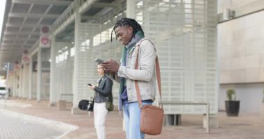 Otobüs durağına vardığında, 30 'lu yaşlardaki Afro-Amerikan adam telefonla arıyor, kilidi açıyor, kayıyor, gülümsüyor. Kentsel, teknoloji, iletişim, yaşam tarzı, gündelik, modern, kamusal