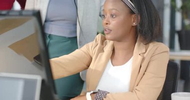 Raporu incelerken, çeşitli kadın iş arkadaşları masaya eğilip, monitörden görüşlerini paylaşıyorlar. İşbirliği, takım çalışması, ofis, meslek, tartışma, iletişim, modern