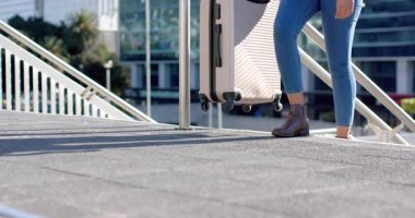 Rampa görüyor, bavulu çeken bir kadın binaya girmek için rampaya tırmanıyor, boşluğu kopyalıyor. Seyahat, hareketlilik, modern mimari, eğlence, yaşam tarzı, ulaşım, açık hava