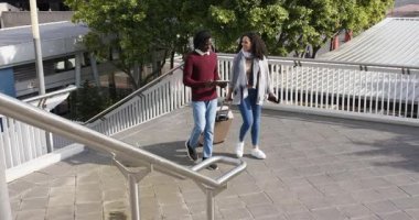 Çeşitli çiftler tablet üzerinden köprüden köprüye tırmanıyor, bavulu sürerken güzergahı kontrol ediyorlar. Kentsel, seyahat, iletişim, teknoloji, hareketlilik, arkadaşlık, navigasyon