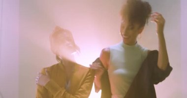 Grunge Stüdyolarındaki gülümseyen kadın canlı ışık efektleriyle dans ediyor. Dans, gece kulübü, parti, kutlama, hareket, enerji