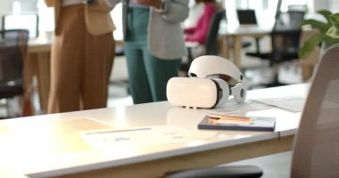 Aşağıdaki tablet Afro-Amerikan iş arkadaşlarının tablet tıklamasına ve VR kulaklık takmasına yol açtı. İşbirliği, yenilik, teknoloji, fütürizm, takım çalışması, profesyonel, ergonomik