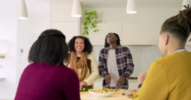 Mutfak adasında sebze keserken neşeli alkışlara cevap veren arkadaşlar. Aşçılık, yoldaşlık, modern, yaşam tarzı, sosyal, neşeli, hayat dolu