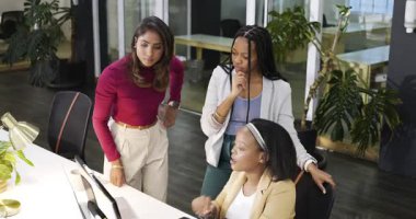 Ofisteki çeşitli kadın iş arkadaşları inceleme sırasında yazı yazıyor, işaret ediyor ve monitöre kafa sallıyorlar. İşbirliği, takım çalışması, modernlik, profesyonellik, beyin fırtınası, iletişim, başlangıç