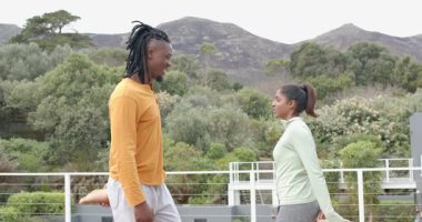 Çeşitli jimnastik kıyafetleri giyip karşılıklı cesaretlendirici sözler söyleyip çatıda beşlik çakıyorlar. İşbirliği, yoldaşlık, açık hava, refah, motivasyon, arkadaşlık, fitness