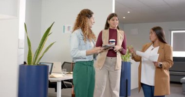 Çeşitli kadın meslektaşların proje planlaması, işaret çizelgesi, kaydırmalı tablet ve ofiste kahkahalar. İşbirliği, takım çalışması, profesyonellik, şehir ofisi, modernstil, iş toplantısı, verimlilik