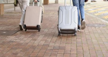 Çeşitli arkadaşlar otobüs durağının önünden bavullarını taşıyorlar, kırmızı ışıkta kahve içiyorlar, yürümeye devam ediyorlar. Ulaşım, seyahat, şehir manzarası, şehir, yaşam tarzı, macera, gelişigüzel