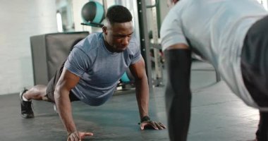 Afrika kökenli Amerikalı erkekler, takım çalışmasıyla motive edilmiş spor paspasının üzerinde karşılıklı olarak şınav çekiyorlar. Spor, güç, takım çalışması, işbirliği, eğitim, atletizm, motivasyon