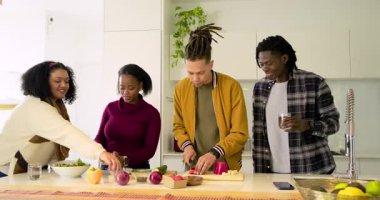 Çeşitli arkadaşlar biber doğramaya, sos dökmeye, mutfak adasında salata fırlatmaya tepki veriyor. Aşçılık, aşçılık, takım çalışması, yaşam tarzı, modern, enerjik, sosyal