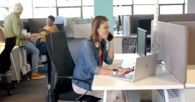 Çeşitli iş arkadaşları telefonla görüşüyor, kağıtları değiş tokuş ediyor, ofiste dizüstü bilgisayarda yazıyor, kopyalama alanı kullanıyor. İşbirliği, takım çalışması, iletişim, modern, profesyonel, üretkenlik, teknoloji