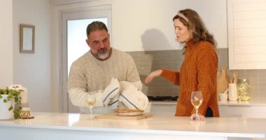 Mutfak adasında yeni pişmiş turta sunan, şarap kadehlerini kutlayan romantik bir çift. Romantizm, kutlama, samimi, evcil, sıcak, sevgi, gurme