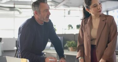 Çeşitli iş arkadaşları planlama için işaret seçiyor, kağıtları tutuyor, ofis masasına yapışkan notlar bırakıyor. İşbirliği, takım çalışması, beyin fırtınası, iletişim, profesyonel, modern, üretkenlik