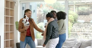 Farklı arkadaşlar oturma odasında beyaz VR kulaklıklar alıyor kontrolleri denetliyor ve kayışları ayarlıyorlar. Teknoloji, yenilik, sosyal, bağlantı, modern, boş zaman, işbirliği