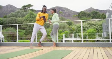 Çeşitli fitness partnerleri akıllı telefonda egzersiz uygulaması açıyor ve güverte teftiş planında suyu yudumluyor. Sağlıklı yaşam tarzı, açık hava aktivitesi, işbirliği, refah, rahatlık, doğa, bağlantı