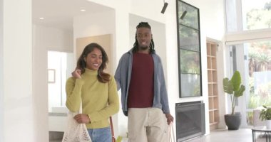 Çeşitli çiftler eve ellerinde alışveriş çantalarıyla giriyor. Yemek masasına eşyalarını yerleştiriyorlar. Sürdürülebilirlik, çevre dostu, yaşam tarzı, modern tasarım, ev içi, doğal ışık, gündelik