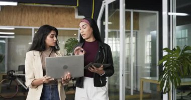 Dizüstü bilgisayar ve tableti inceleyen çeşitli kadın çalışanlar tarafından inceleniyor. İşbirliği, takım çalışması, modern, üretkenlik, aygıtlar, çalışma alanı, profesyonel