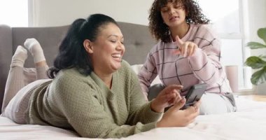 İspanyol ve Afrikalı Amerikalı arkadaşlar ekranda gülüyor ve yataktaki yazıları işaret ediyorlar. Arkadaşlar, sosyal, rahat, rahat, yaşam tarzı, iletişim, canlı