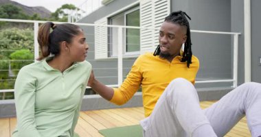 Çeşitli çiftler birbirlerini cesaretlendiriyor ve ahşap güvertede yeşil yoga minderlerinde beşlik çakıyorlar. Refah, huzur, farkındalık, bağlantı, birlik, uyum, motivasyon