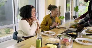 Çeşitli ev sahipleri evde hindi ve salata servisi yapıyor, misafirler alkışlıyor ve yemeğe başlamak için eğiliyor. Neşeli, neşeli, hasat, kutlama, samimi, aile, geleneksel