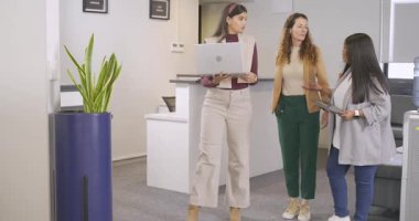 Resepsiyona girip tableti araklayan çeşitli iş arkadaşları dizüstü bilgisayarı ayarlamak için duraksamayı gösteriyor. Profesyonel, işbirliği, modern, iş dünyası, takım çalışması, kurumsal, iletişim