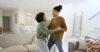 Çift ellerini uzatır, dans eder, kanepede ve köpekle evde döner ve sallanır. Romantizm, bağlantı, yakınlık, sevgi, yaşam tarzı, ev içi, gündelik