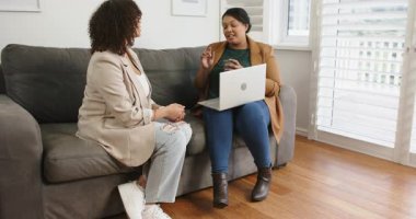 Çeşitli bayan arkadaşlar kanepede diz üstü bilgisayar ve el kol hareketleri yaparak fikir alışverişinde bulunuyorlar. İşbirliği, tartışma, iletişim, arkadaşlık, gündelik, modern, profesyonel