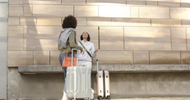 Çeşitli bayan arkadaşlar bavullarını topluyor, şehir meydanında dostlarını selamlıyor, sohbet ediyor, çıkışa hazırlanıyor. Gündelik, arkadaşlık, seyahat, şehir, modern, yaşam tarzı, canlı