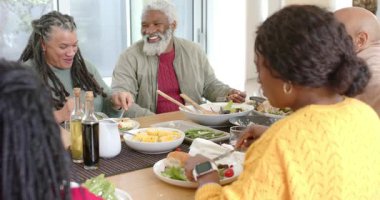 Gülen, çeşitli aileler akşam yemeği için salata ve meze dağıtıyor. Neşe, birliktelik, canlılık, beslenme, gündelik, sıcaklık, kutlama.