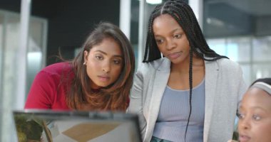 Meslektaşının sandalyeye dönüşmesi, çeşitli kadın iş arkadaşlarının dizüstü bilgisayarla projeyi tartışması. İşbirliği, takım çalışması, profesyonel, modern, çeşitlilik, işyeri, iletişim