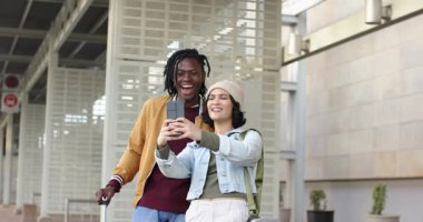 Çeşitli çiftler akıllı telefonları alıyorlar, poz veriyorlar ve gülüyorlar ve selfie 'yi metro platformunda çerçeveliyorlar. Gezginler, samimiyet, adaylık, kentsel, gündelik, yaşam tarzı, neşeli