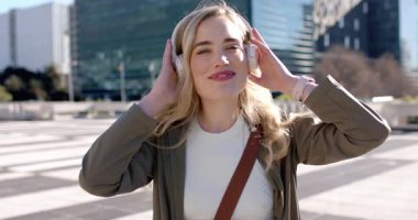 Plaza 'ya girmek, kulaklık takan bir kadın ritme ayak uydurmak, Skyline' a hayran olmak için kulaklıklarını çıkarmak. Kentsel, yaşam tarzı, modern, moda, eğlence, canlı, neşeli