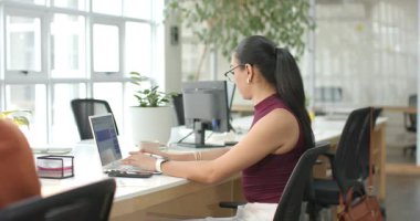 Açık ofiste tablet olarak çalışan, dizüstü bilgisayarda yazan, kopyalayan çeşitli kadın iş arkadaşları var. İşbirliği, takım çalışması, modern, profesyonel, parlak, üretkenlik, iletişim