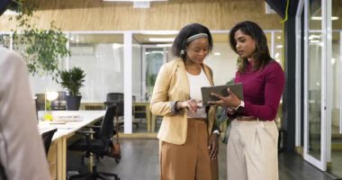 Katıldıktan sonra, çeşitli bayan meslektaşlar tableti tıkırdatıyor ve çeviriyor, ofisteki verileri gözden geçiriyorlar. İşbirliği, takım çalışması, modern, profesyonel, çalışma alanı, üretkenlik, iletişim